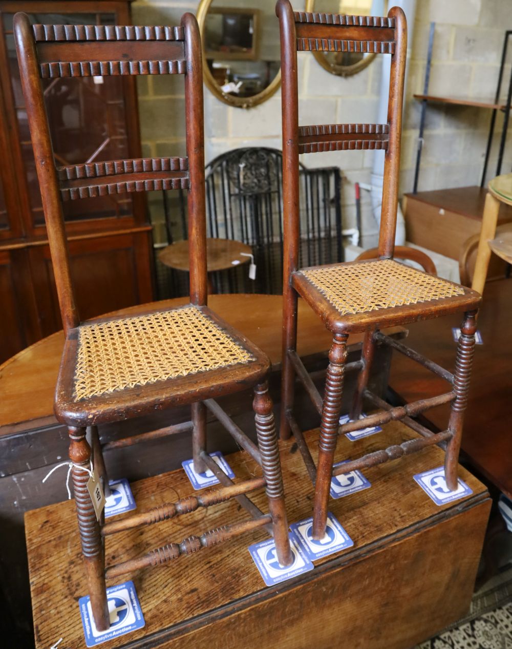 A pair of Regency provincial cane seat correction chairs (one cut down)